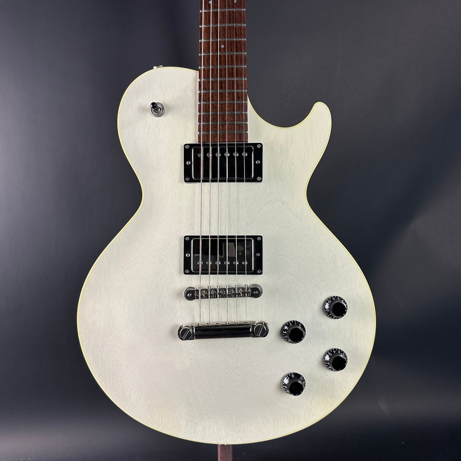 White electric guitar on a dark gray background