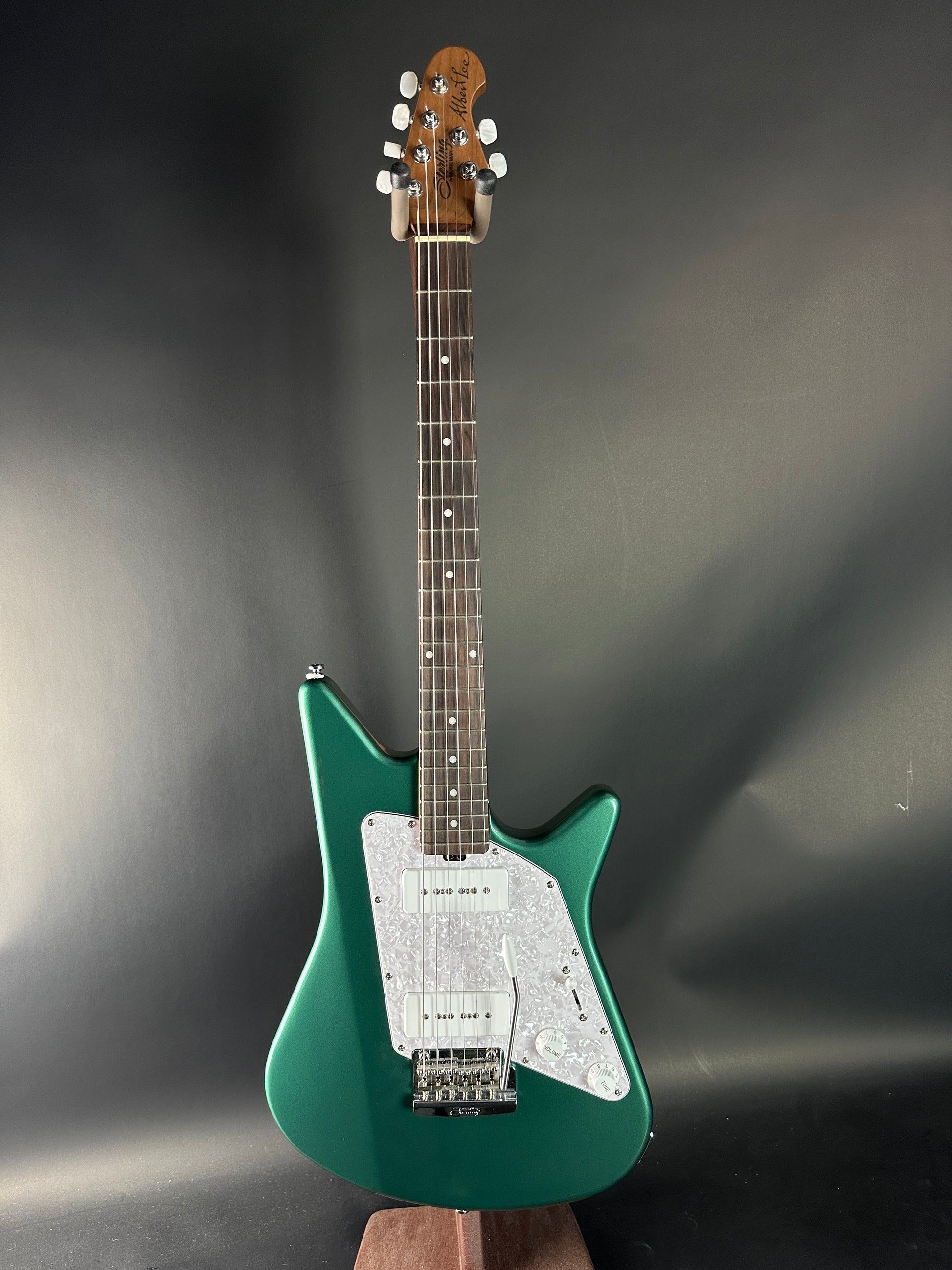 Green electric guitar on a reflective gray surface