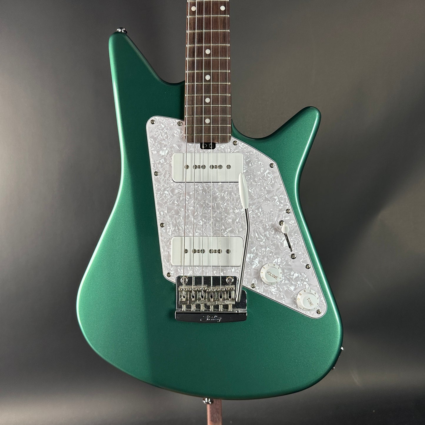 Green electric guitar with a dark gray background