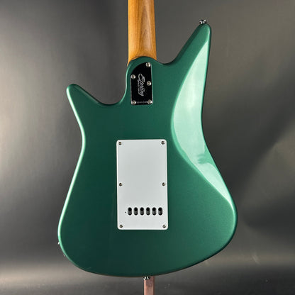 Green electric guitar with a wooden neck on a dark gray background