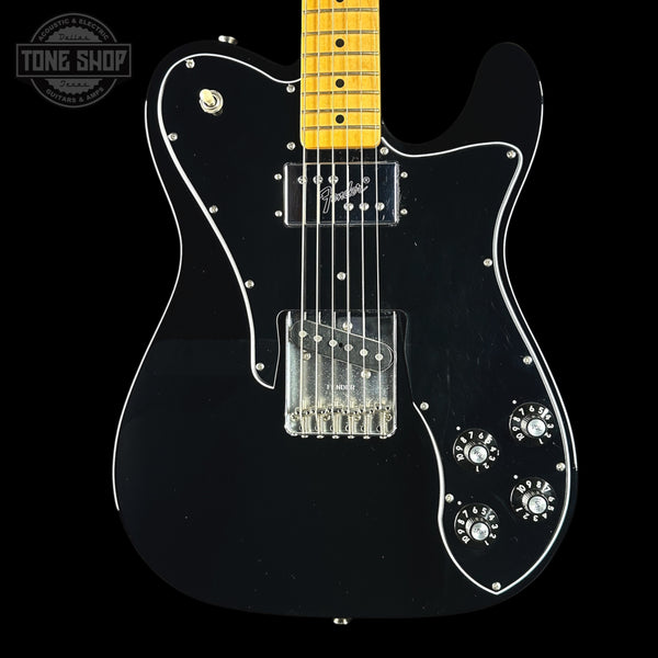 Black electric guitar with a Fender logo on a black background