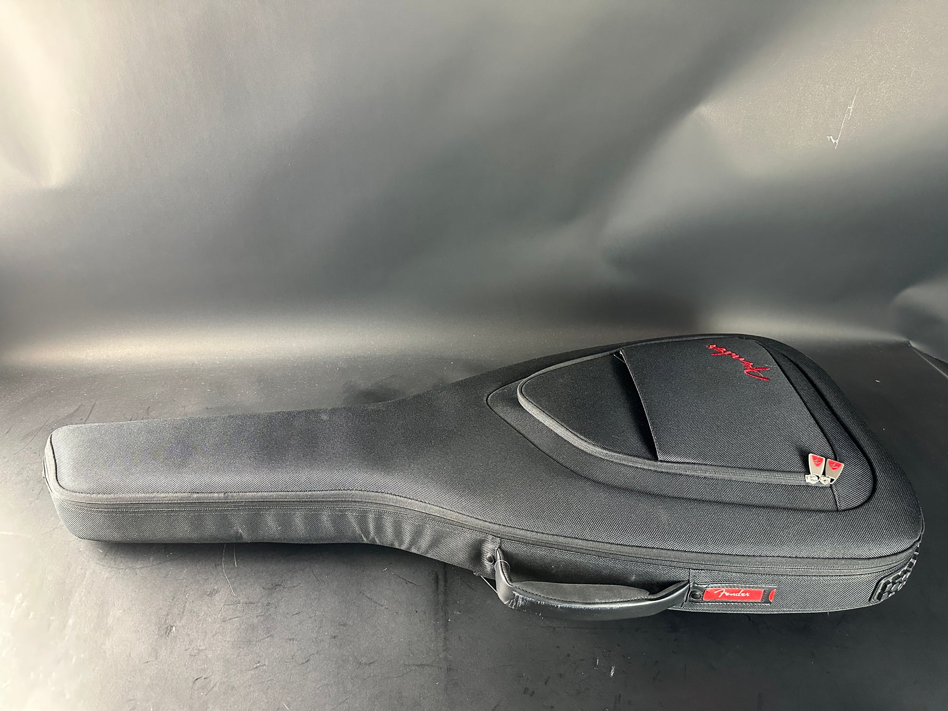 Guitar case with Fender logo on a metallic surface