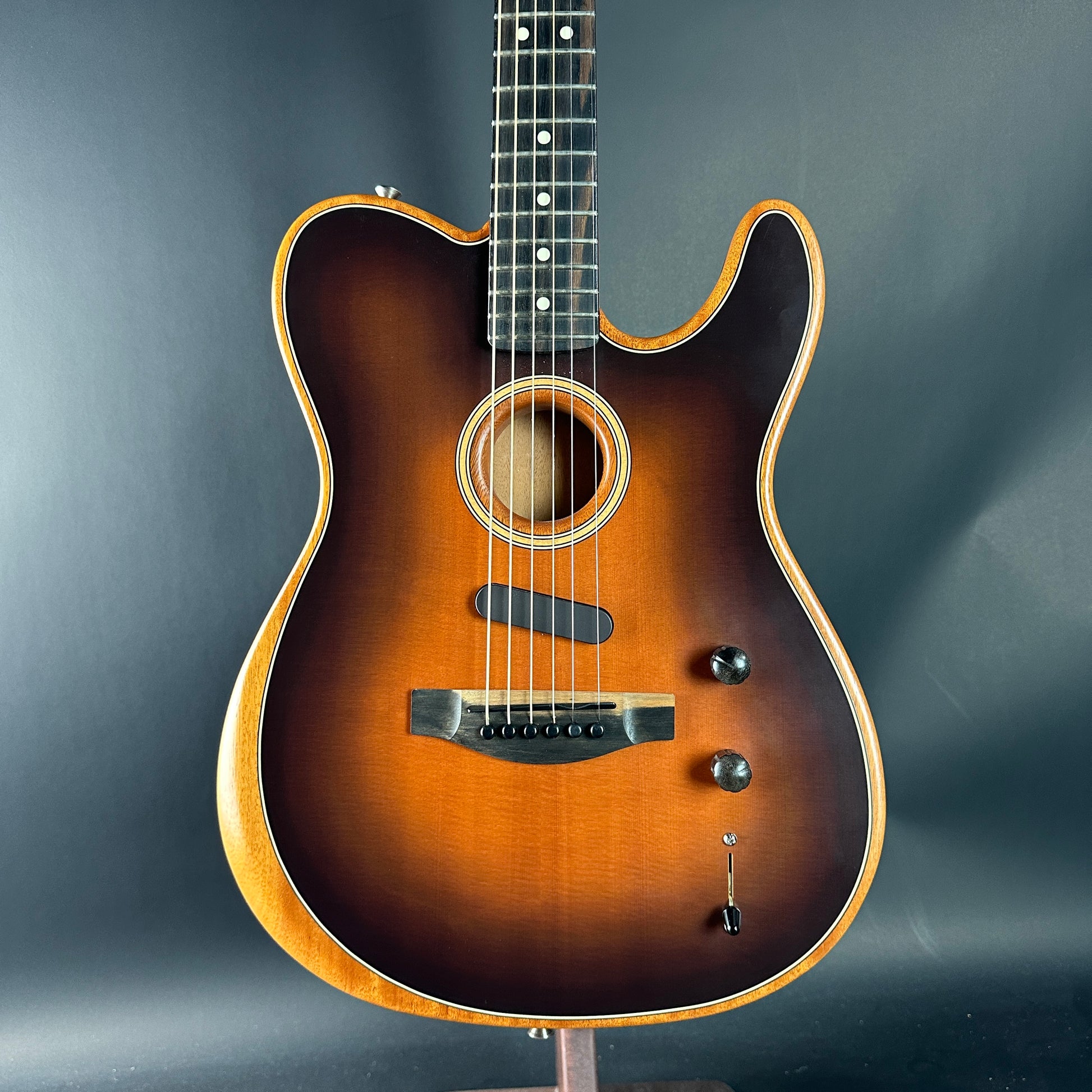 Acoustic guitar with a sunburst finish on a dark gray background