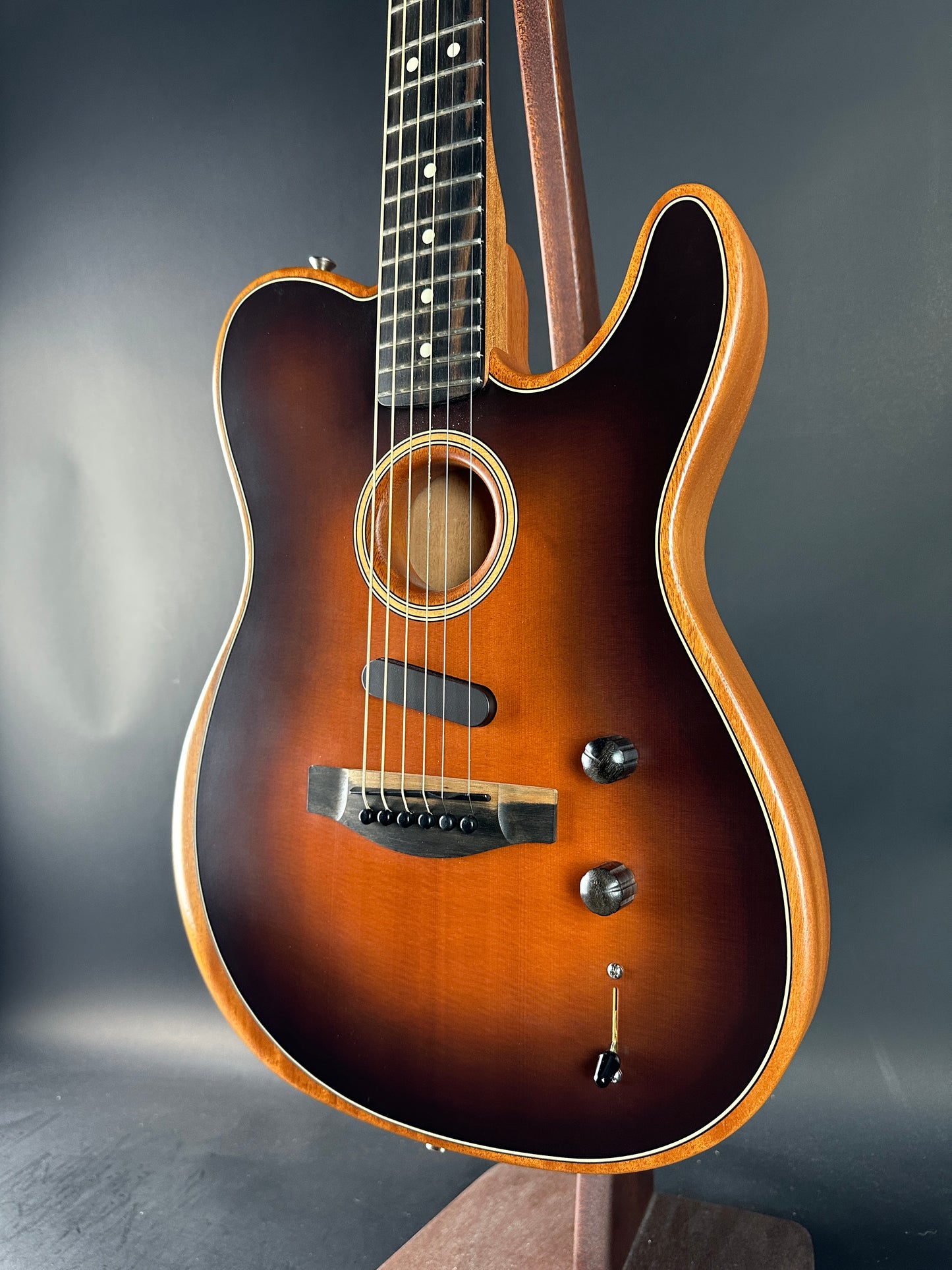Acoustic guitar with a sunburst finish on a dark gray background