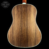 The back of an acoustic guitar with a rich brown wood grain finish, shown against a solid black background with a Tone Shop watermark in the top left corner.