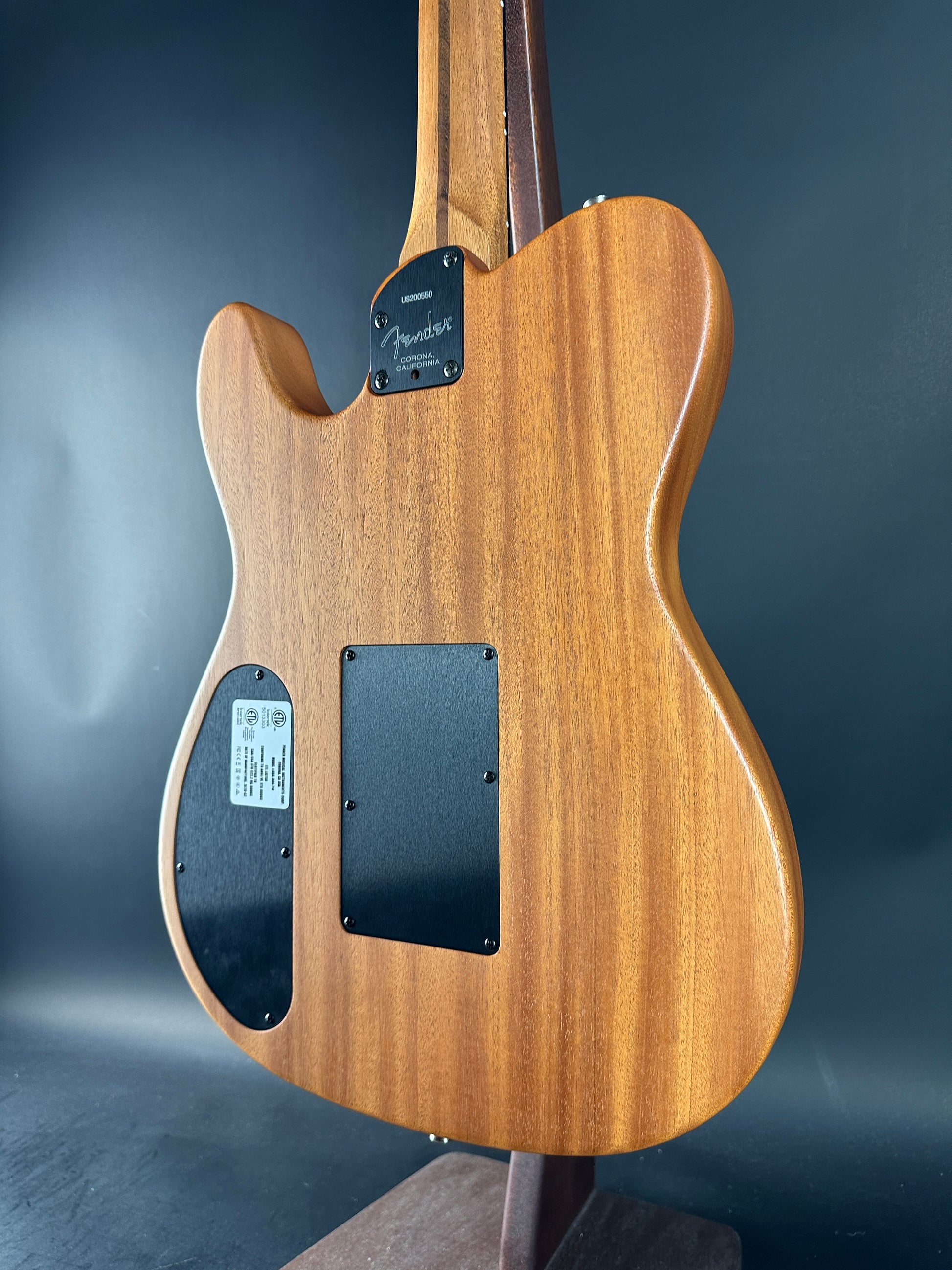 Wooden electric guitar body on a dark background