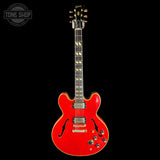 A red Gibson electric guitar with gold hardware, shown vertically against a solid black background. A 'TONE SHOP' watermark is visible in the top-left corner.