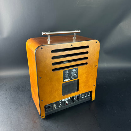 Wooden speaker with metal handle on a dark background