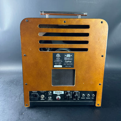 Back view of a guitar amplifier with brand logo on a gray background