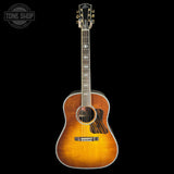 A vintage-style acoustic guitar with a natural sunburst finish, shown vertically against a solid black background. The brand name 'TONE SHOP' is visible as an overlay in the top-left corner.