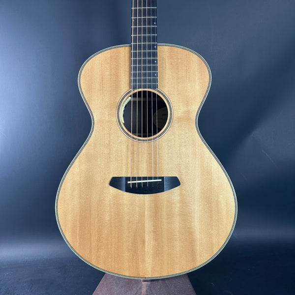 Acoustic guitar with a natural wood finish on a dark blue background