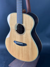 Acoustic guitar with a wooden body and dark neck against a blue background