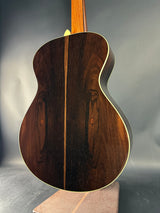 Close-up of a wooden acoustic guitar body on a gray background
