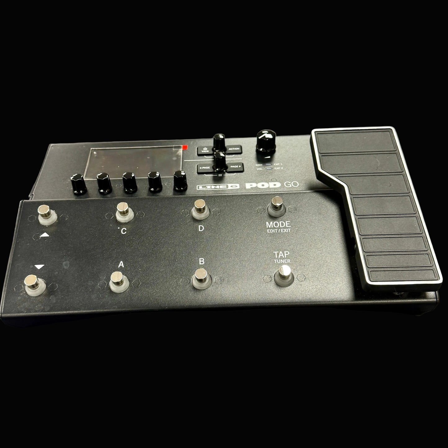 Black electronic device with buttons and a jog dial on a gray surface