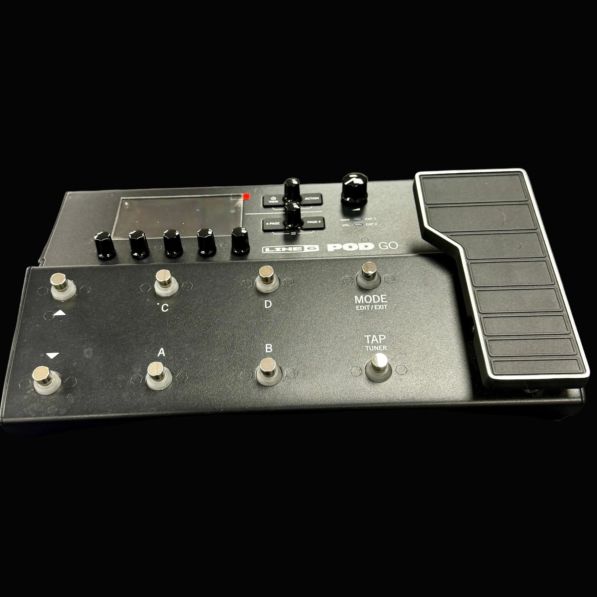 Black electronic device with buttons and a jog dial on a gray surface