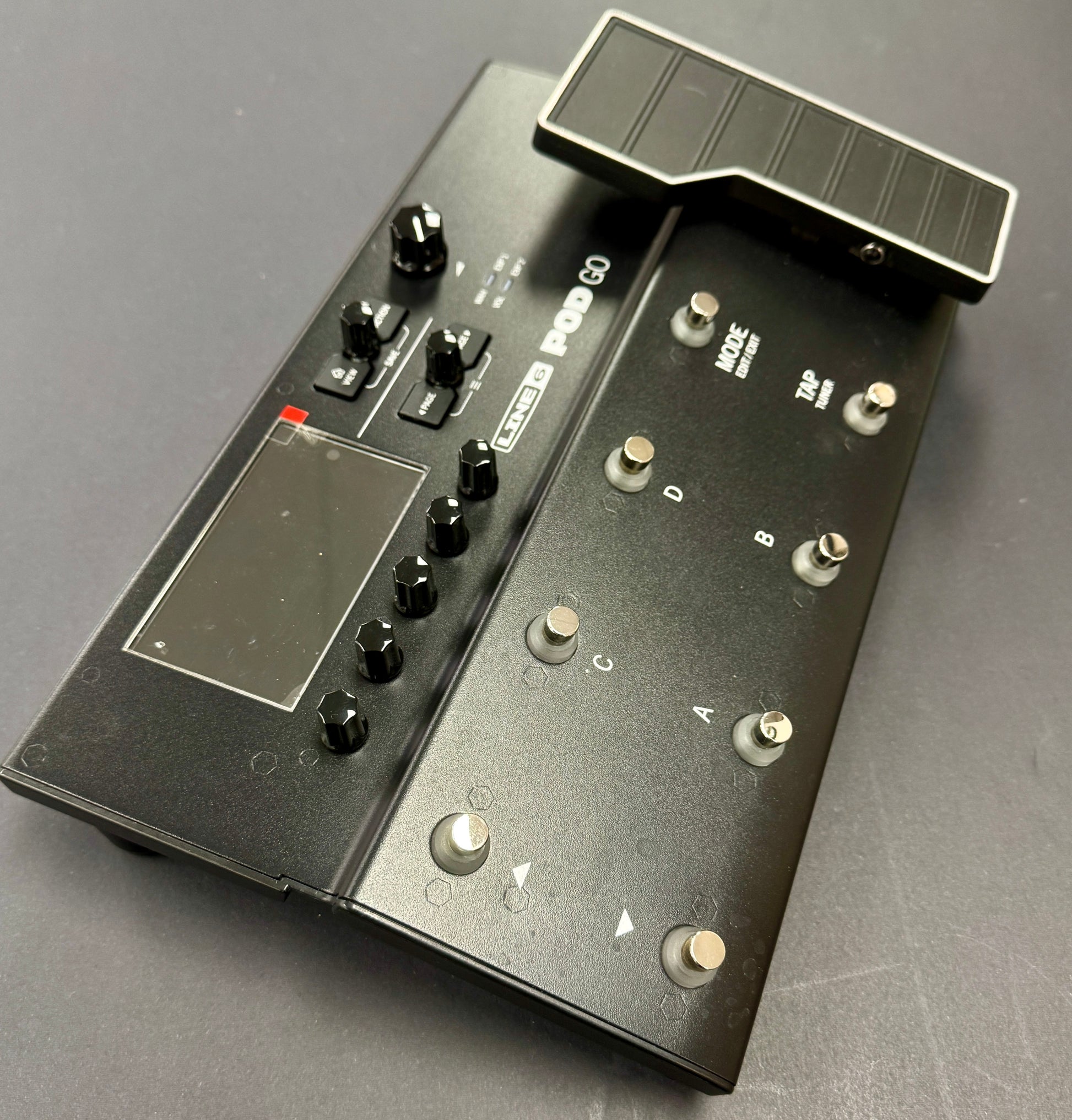 Black electronic device with buttons and display on a gray surface