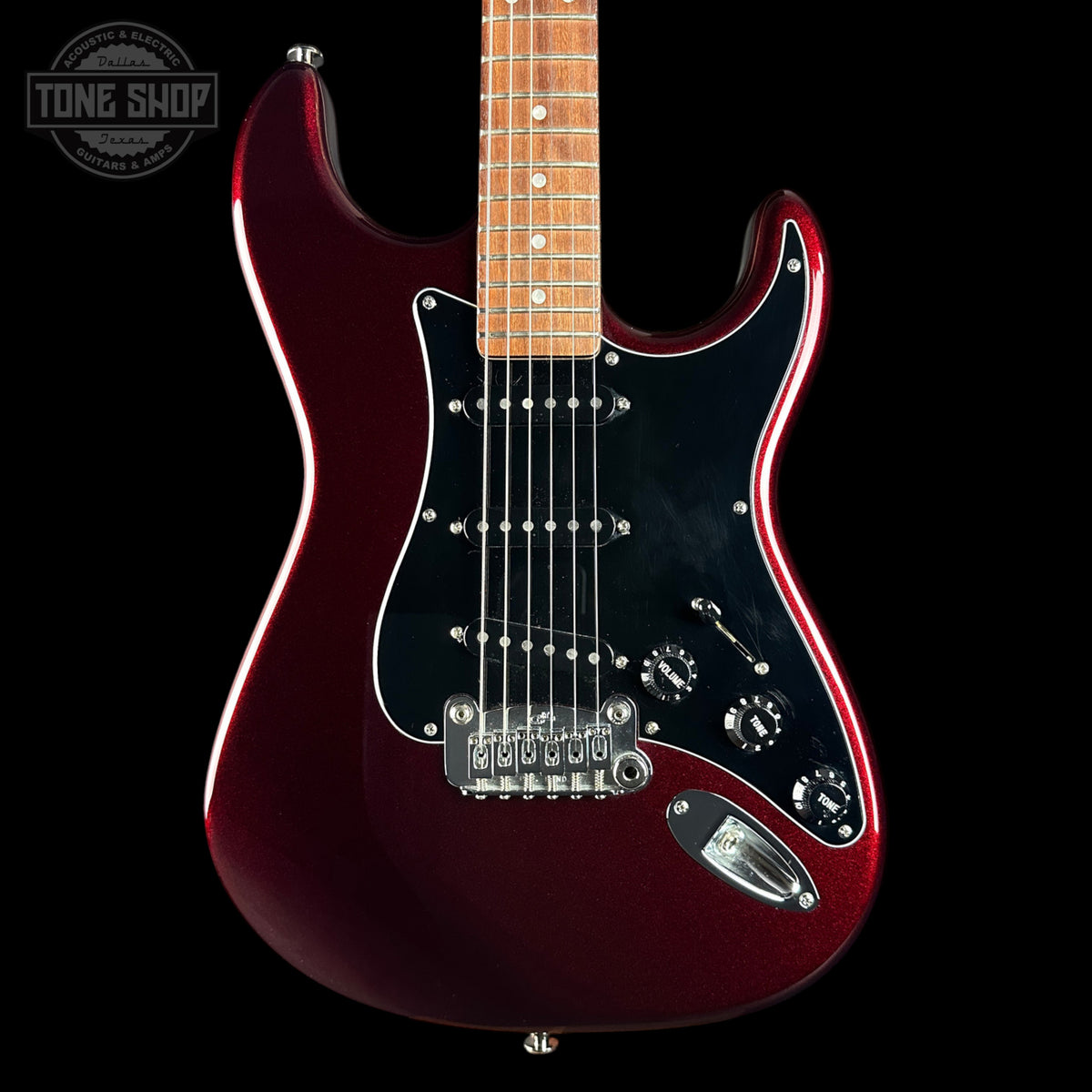 A classic electric guitar with a metallic deep burgundy body, black pickguard, maple neck, and chrome hardware, shown against a solid black background with a Tone Shop watermark in the top left corner.
