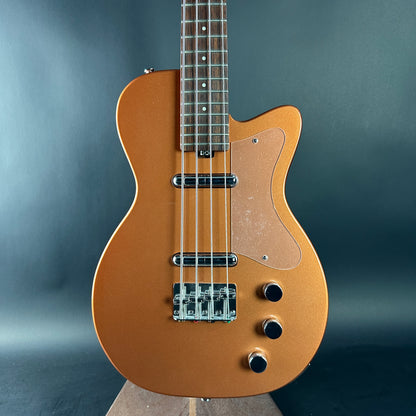 Brown electric bass guitar on a gray background