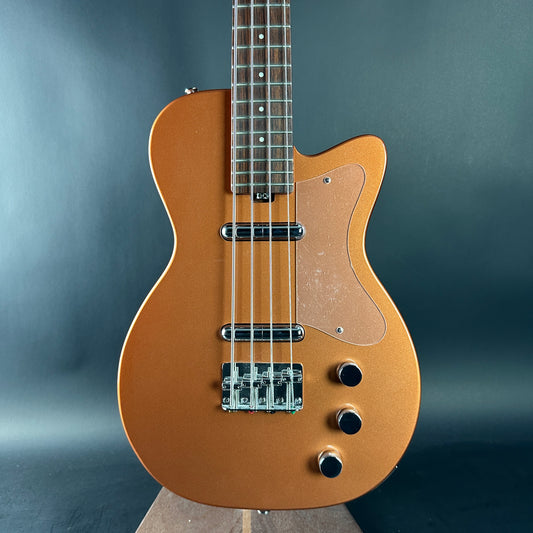 Brown electric bass guitar on a gray background