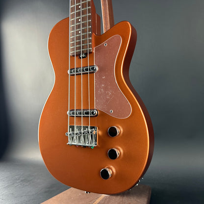 Brown electric bass guitar on a dark background