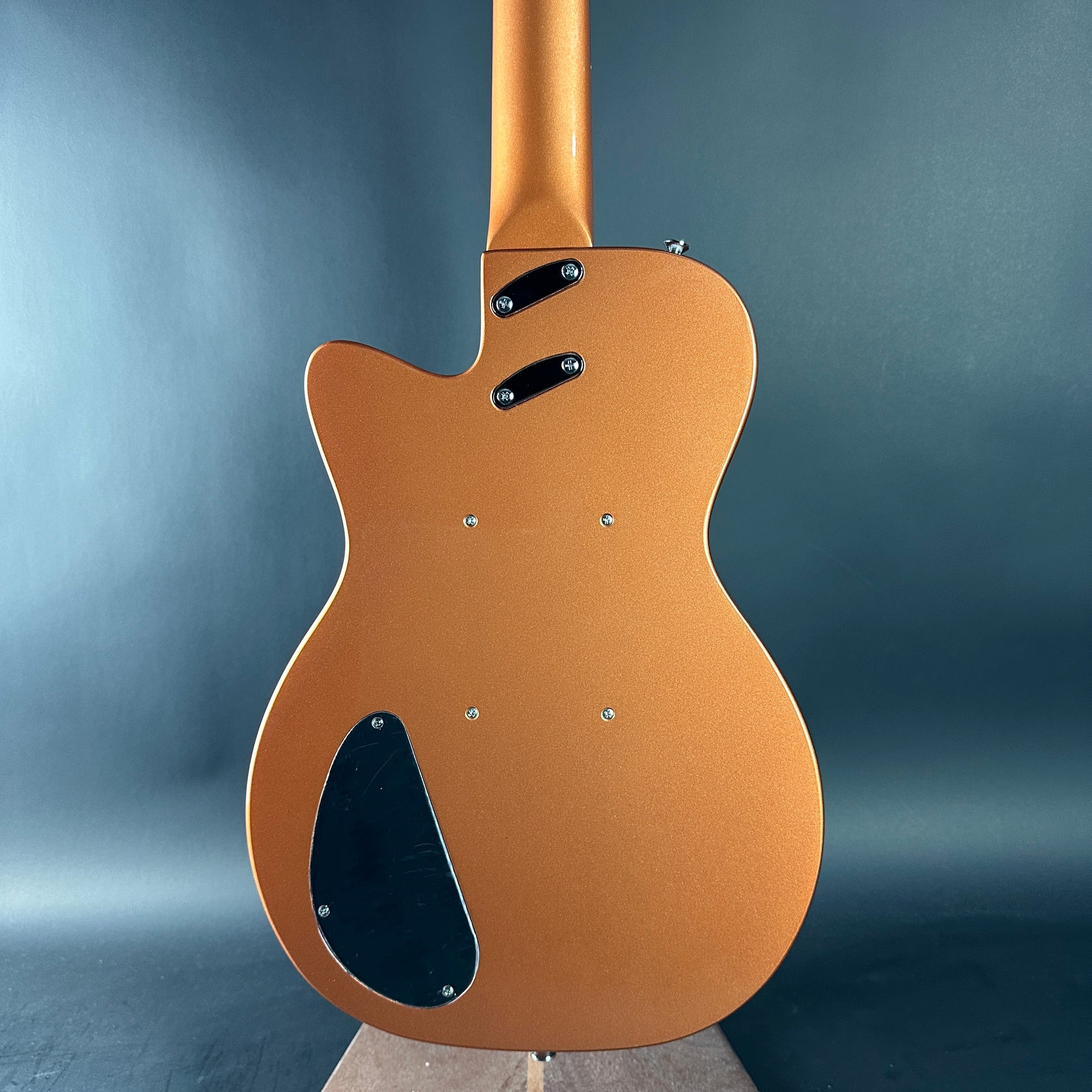 Brown electric guitar on a gray background