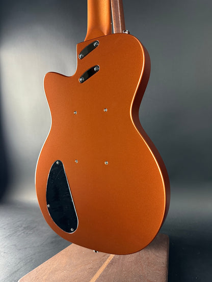 Close-up of a brown electric guitar body on a dark background