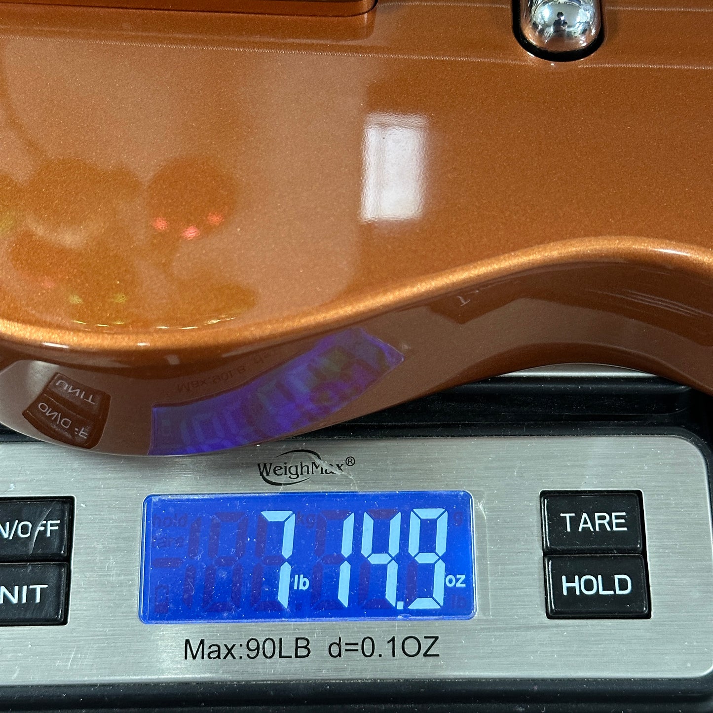 Digital weight scale displaying 7.19 pounds with a brown object on top.