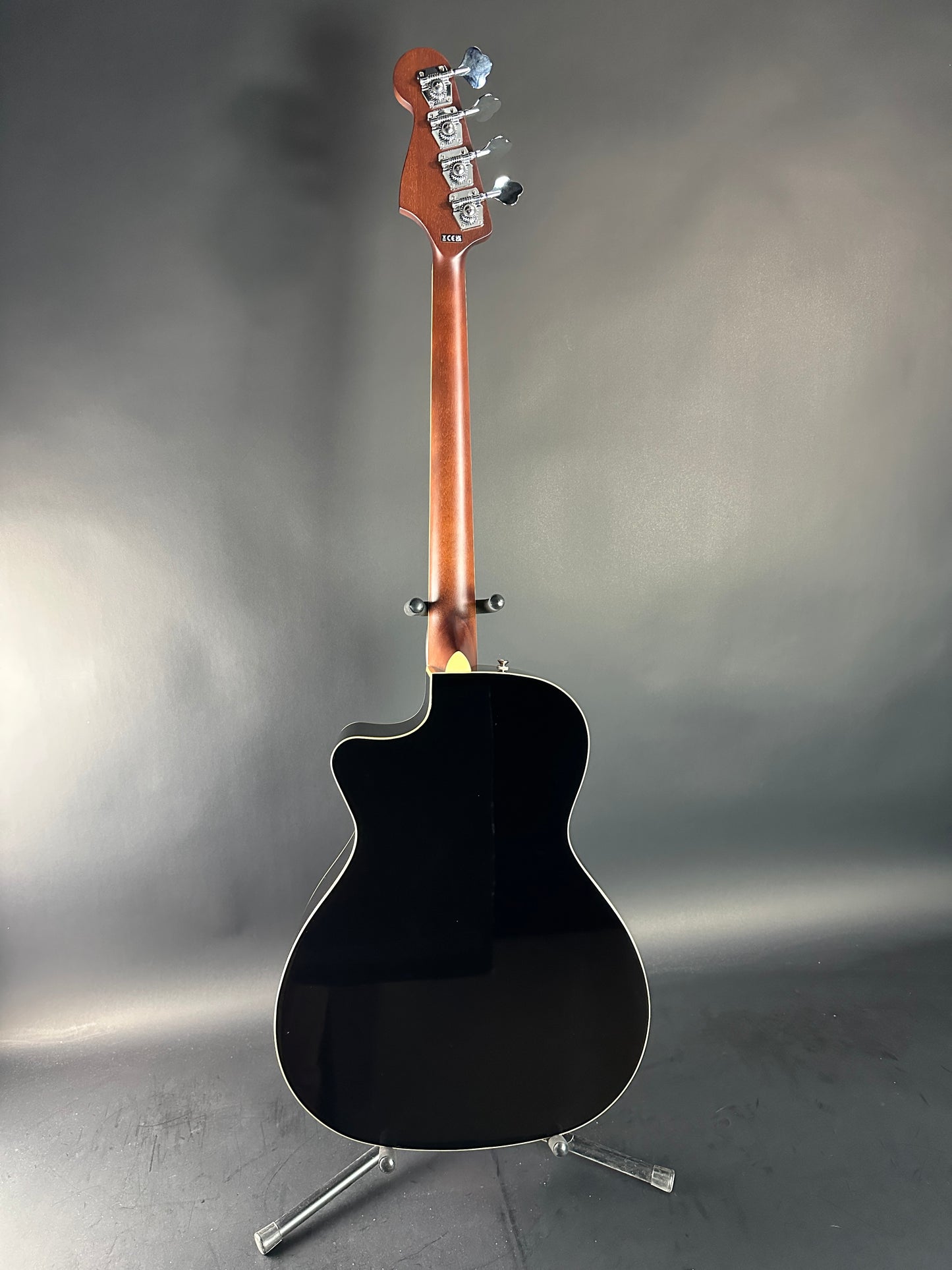 Black acoustic guitar on a reflective gray surface