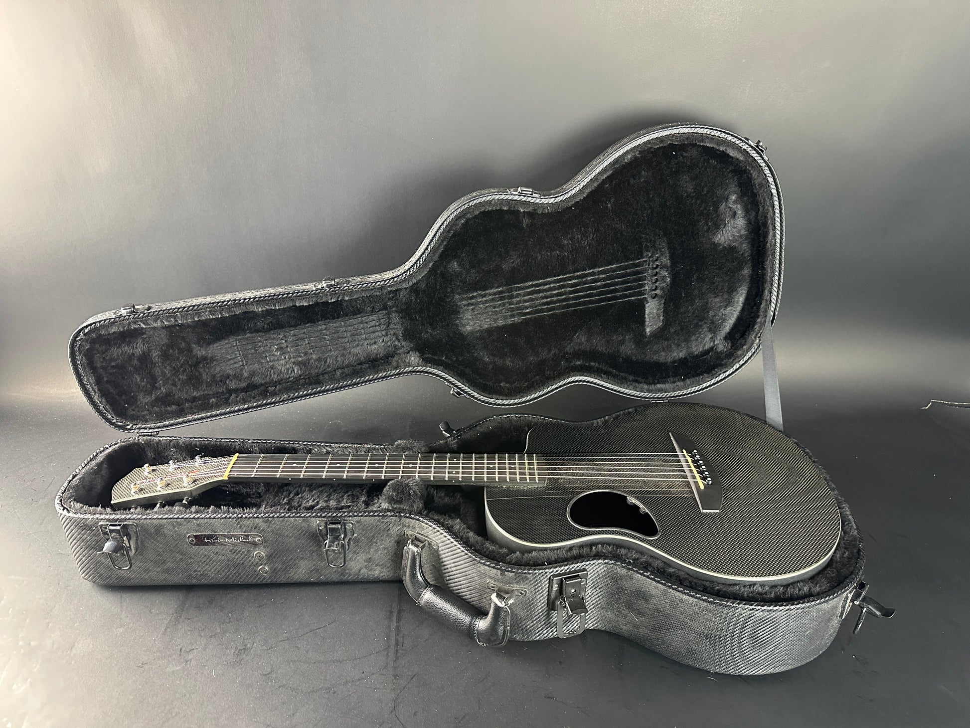 Acoustic guitar in an open case on a gray background