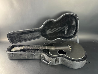Acoustic guitar in an open case on a gray background