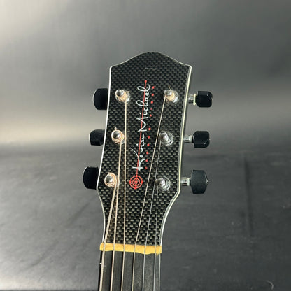 Guitar headstock with brand logo on a gray background
