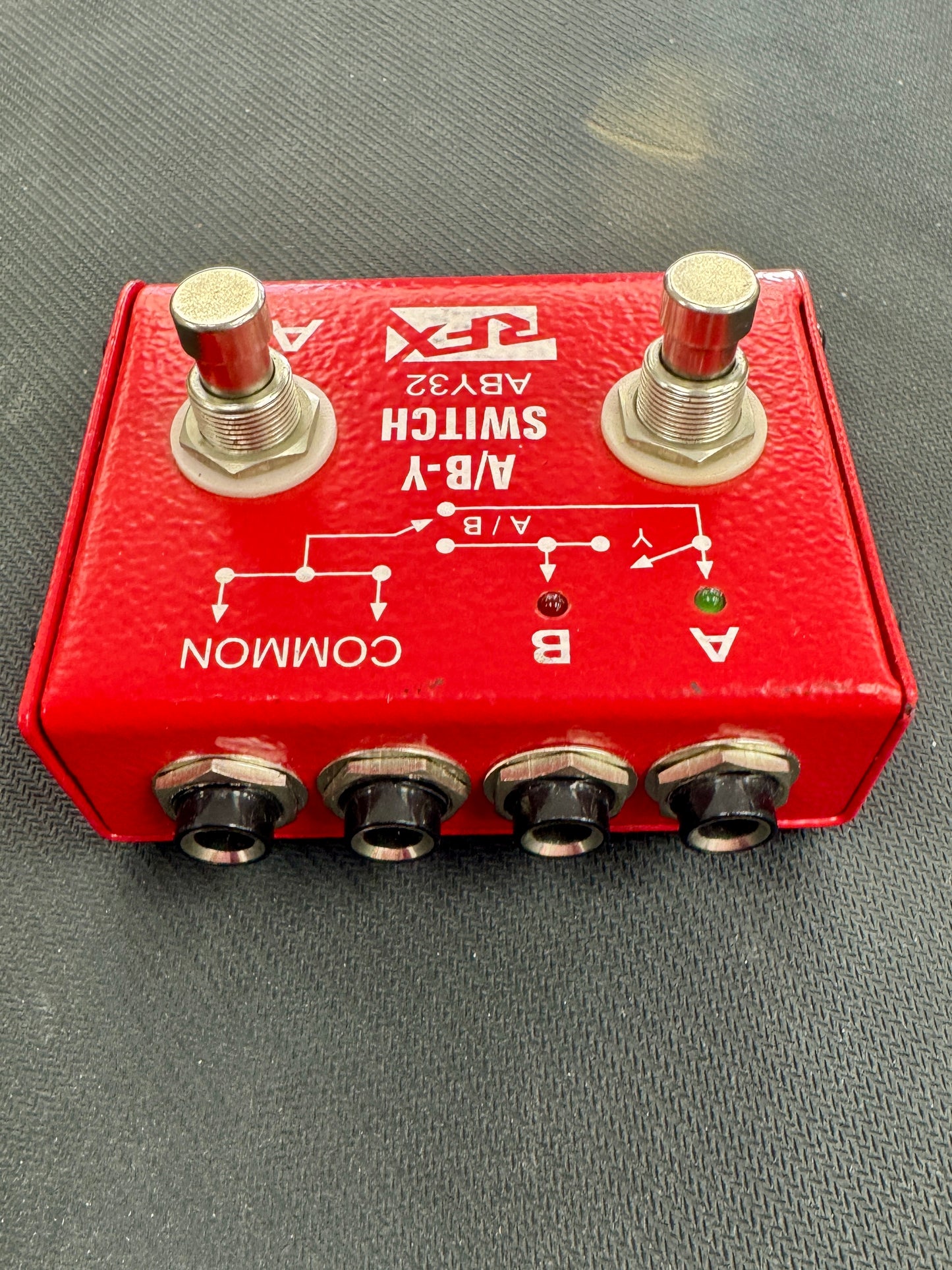 Red switch box with two toggle switches and four socket ports on a gray surface