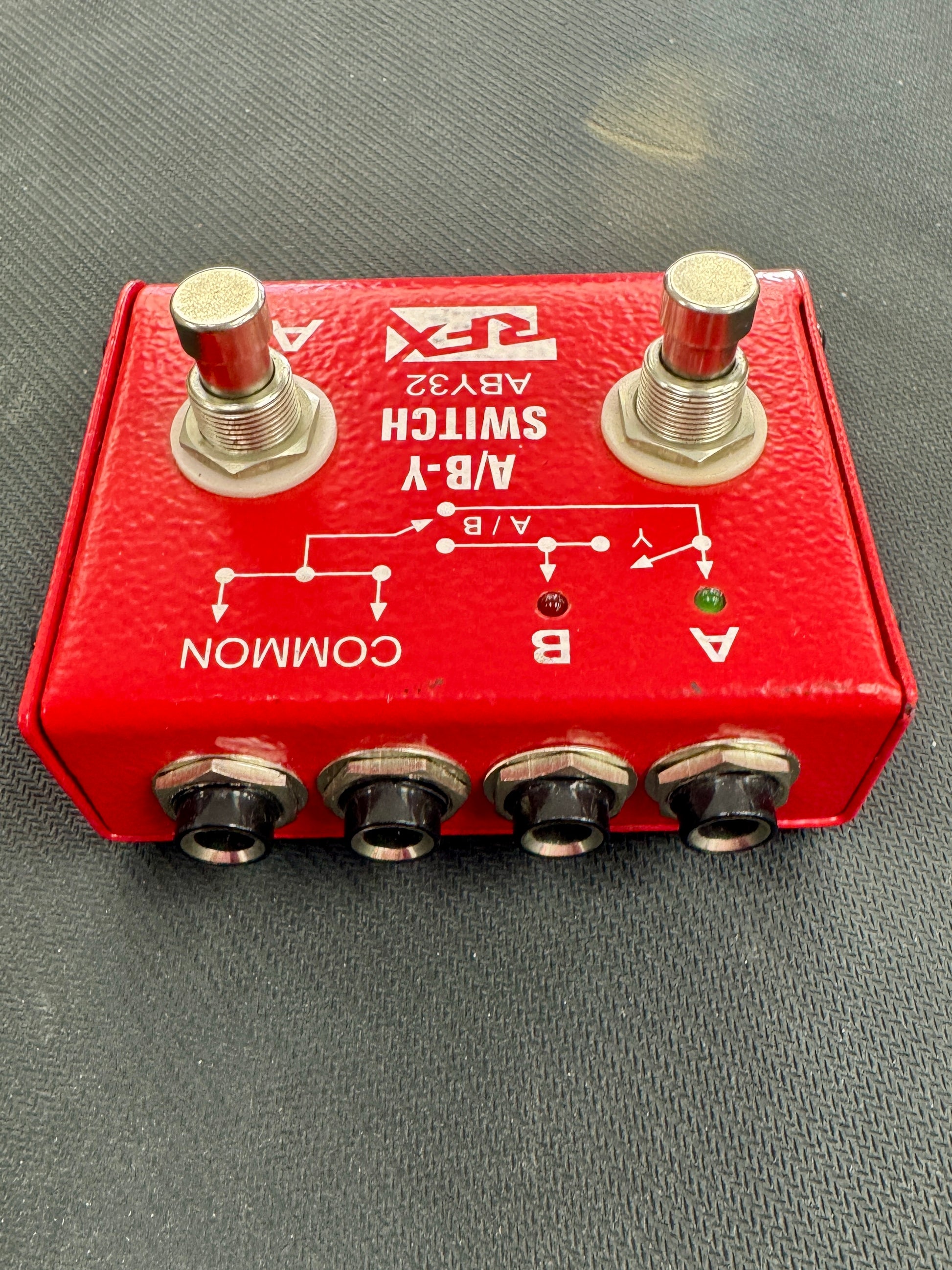 Red switch box with two toggle switches and four socket ports on a gray surface