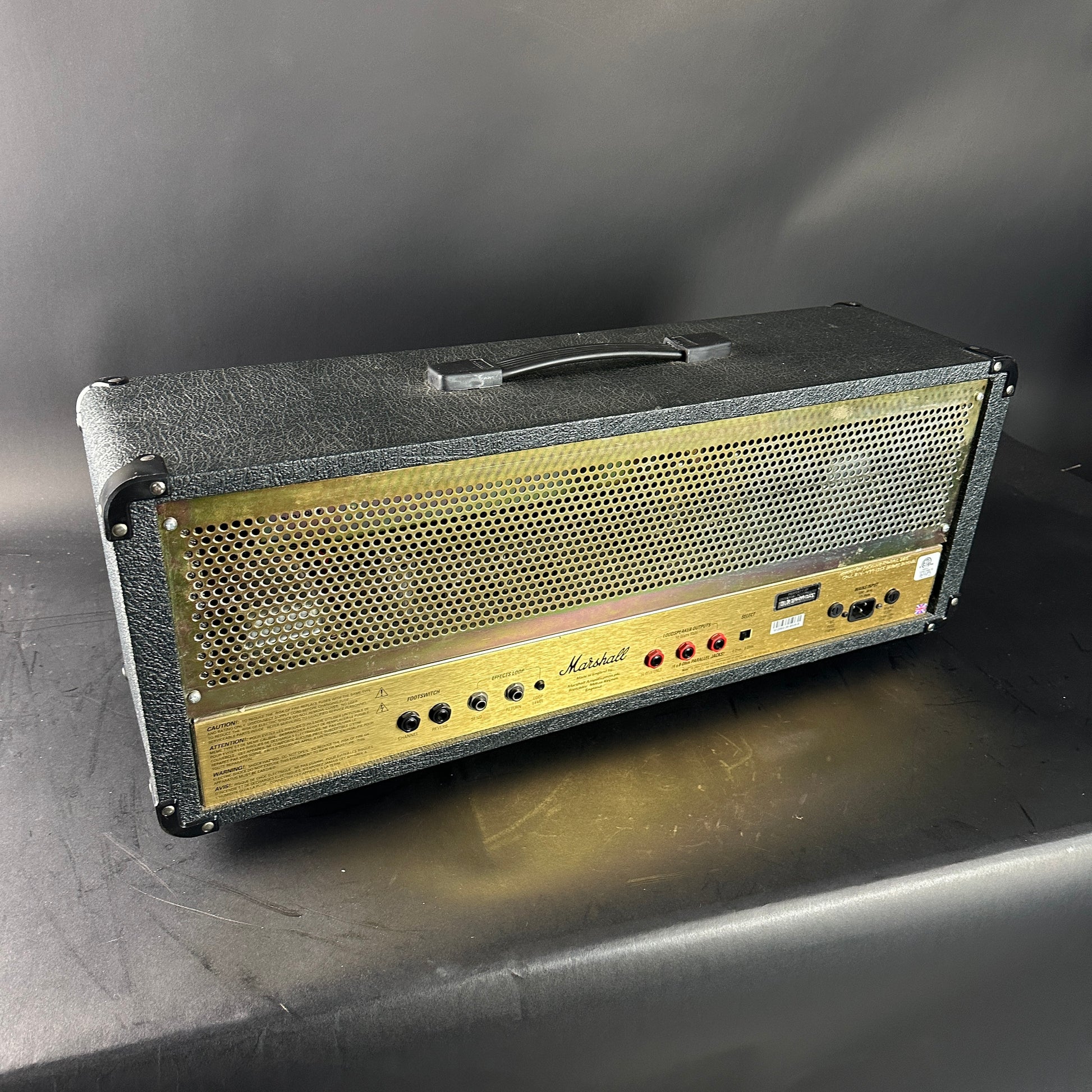 Marshall amplifier head on a gray surface with a dark background