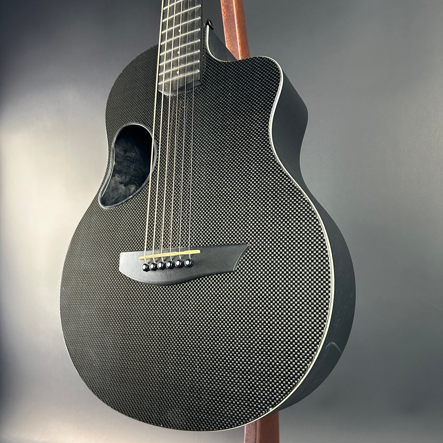Carbon fiber acoustic guitar on a gray background