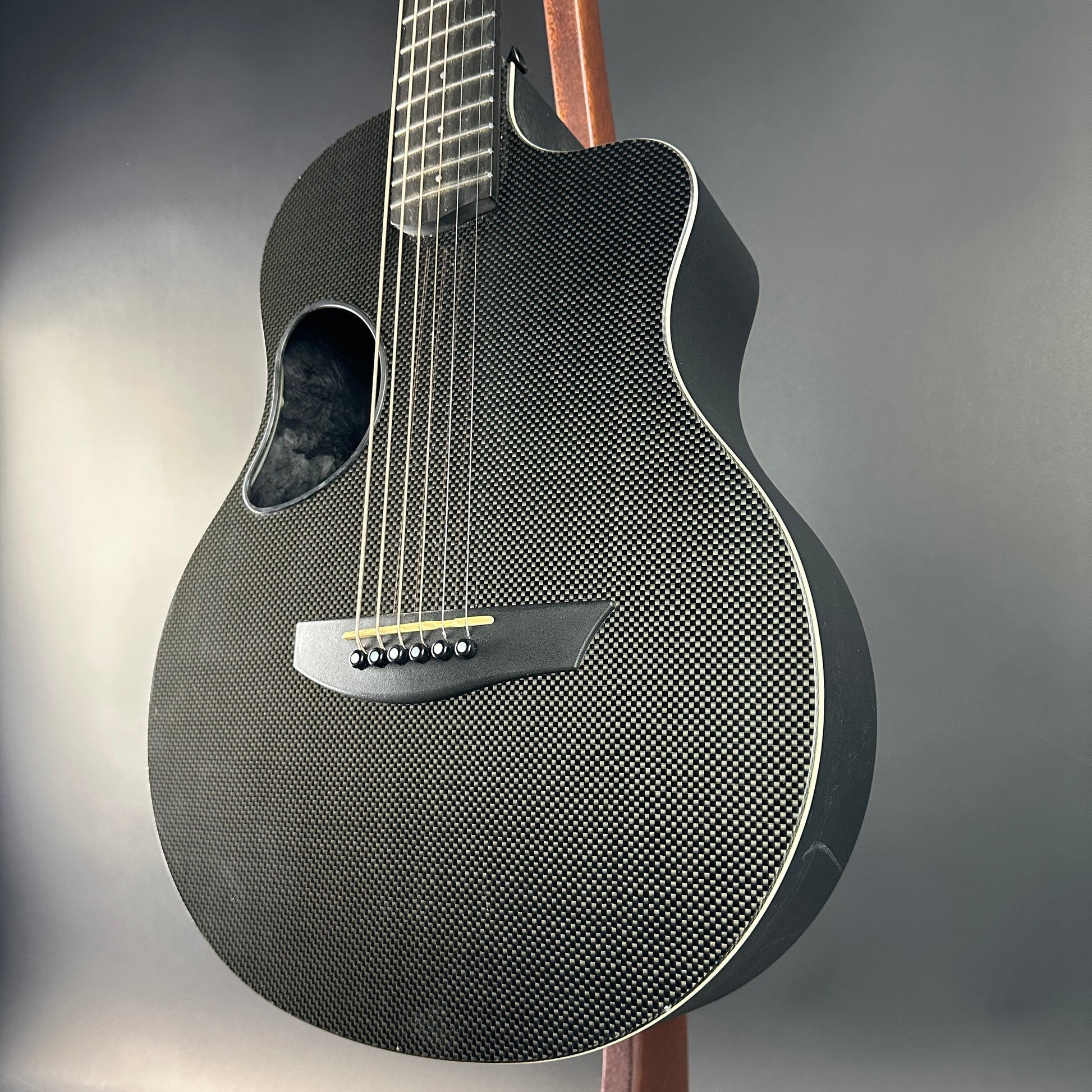 Carbon fiber acoustic guitar on a gray background