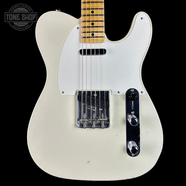 White electric guitar with a black pickguard on a black background, featuring the Tone Shop logo.