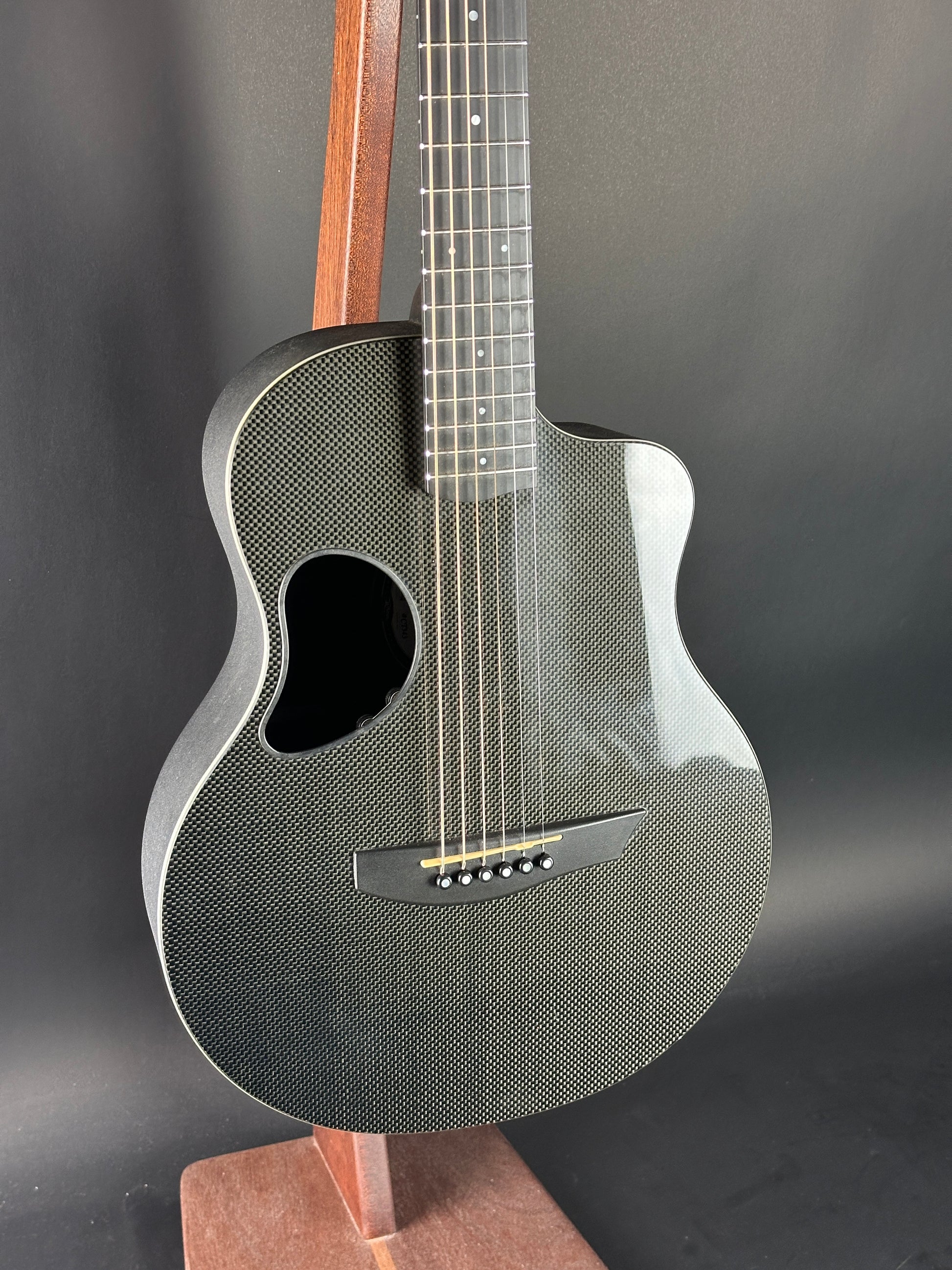Acoustic guitar with a textured body on a dark background