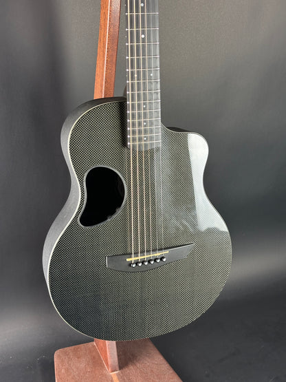 Acoustic guitar with a textured body on a dark background