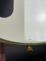 Close-up of a white electric guitar body showing a gold hardware knob, a black binding edge, and a dark pickguard with visible scratches and scuffs.