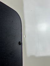 Close-up of a black textured surface with a small black screw fastener, set against a white background.