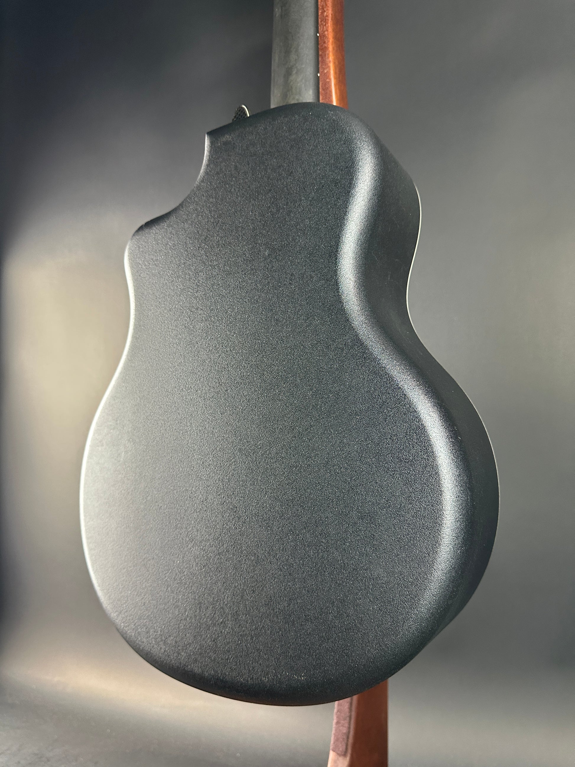 Close-up of a guitar body with a metallic finish on a gray background