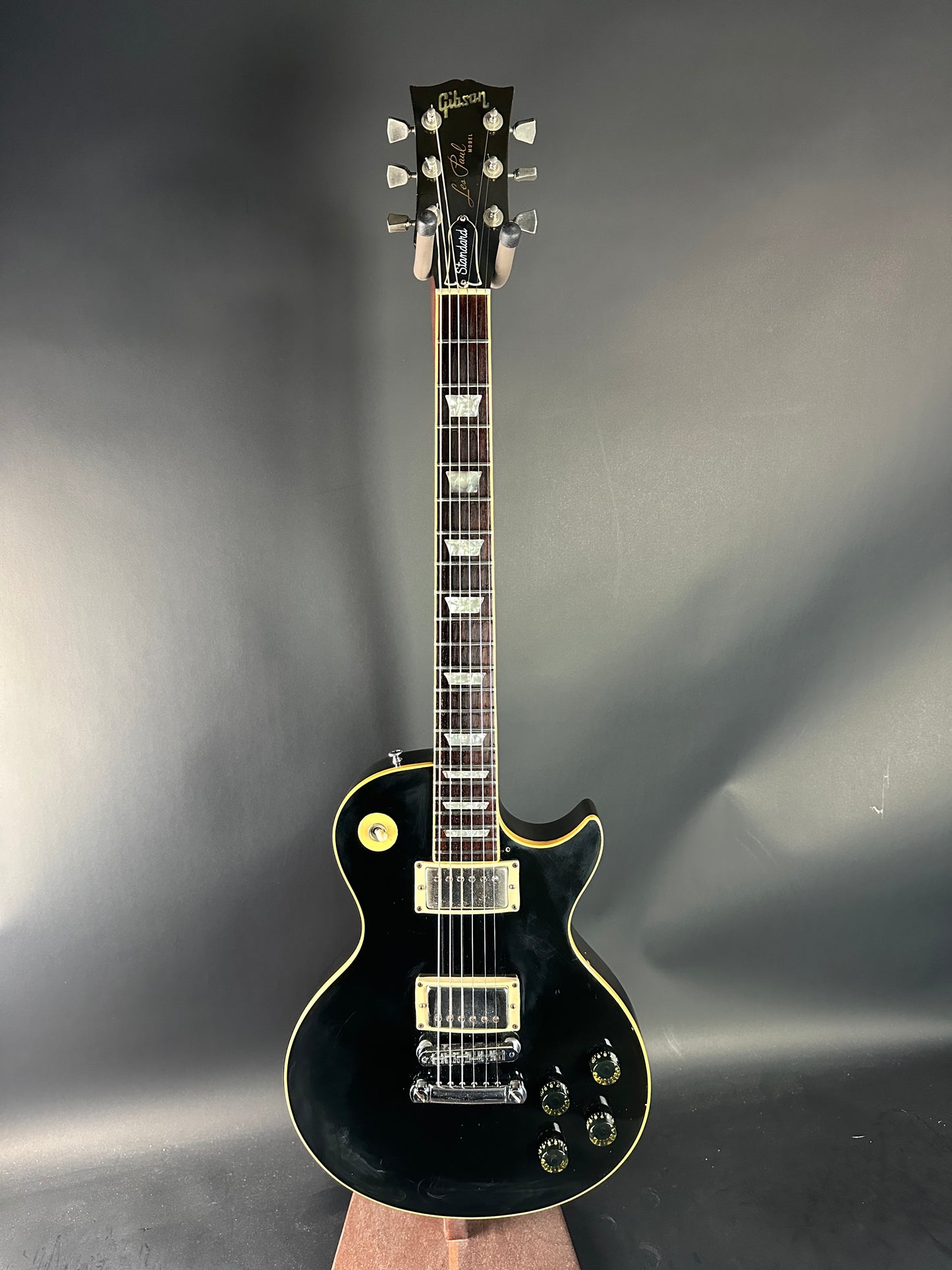 Black electric guitar on a reflective gray surface