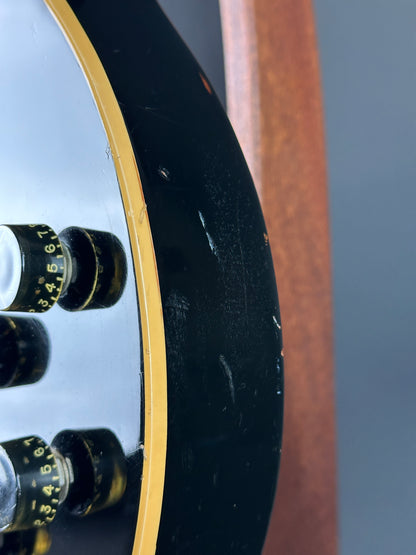 Close-up of a guitar's soundhole with tuning pegs.