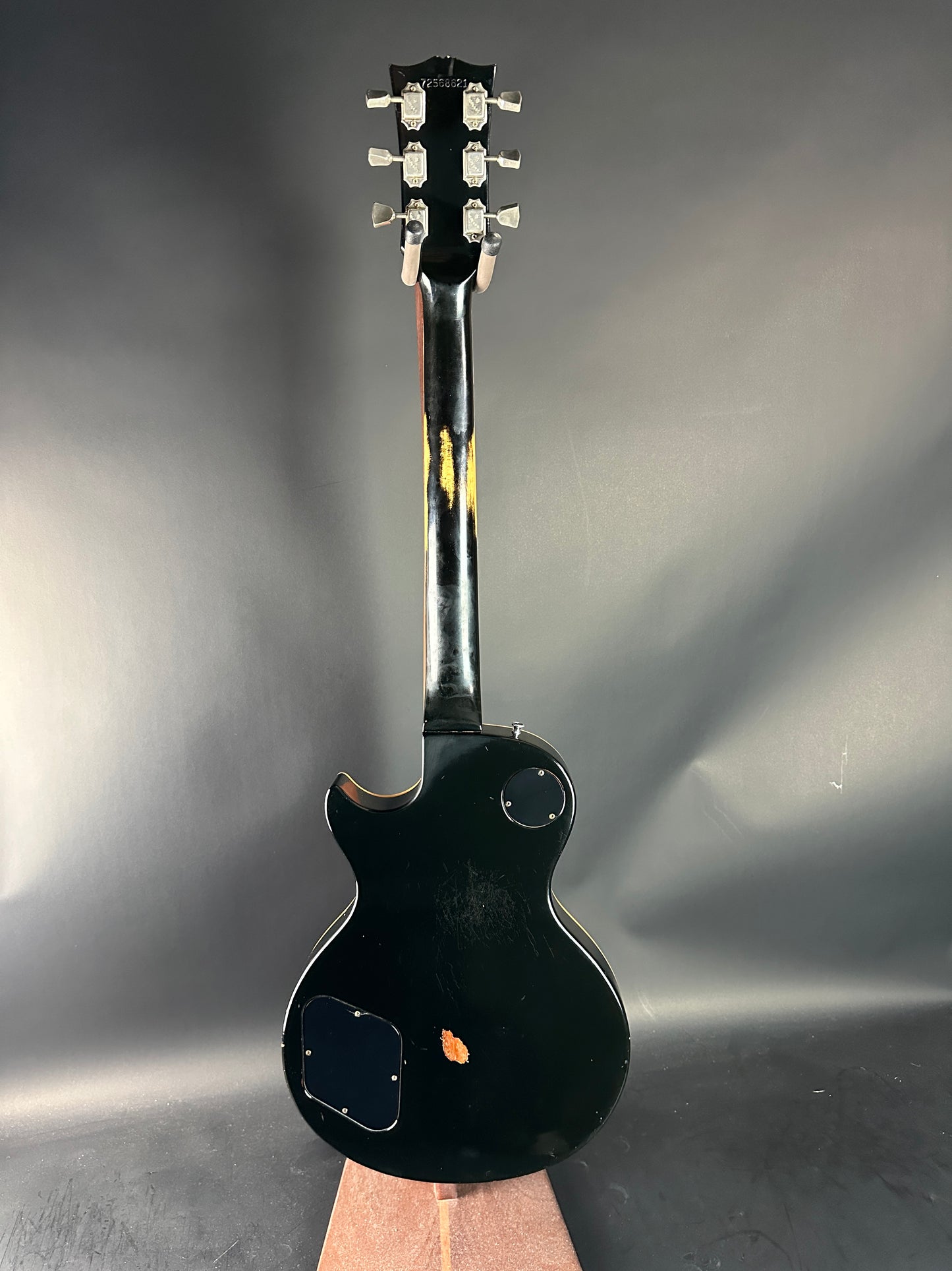Black electric guitar on a reflective gray surface