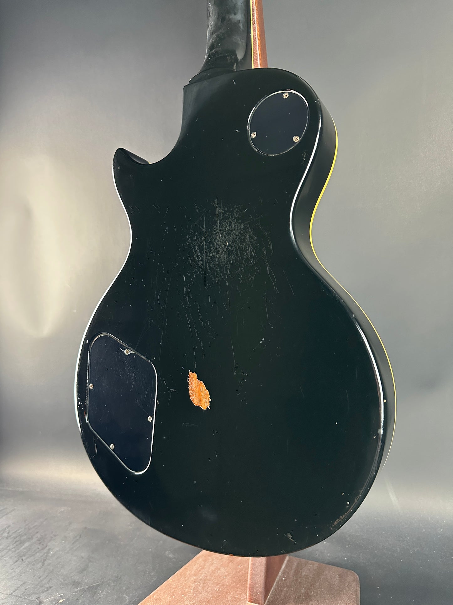 Black electric guitar body on a reflective surface