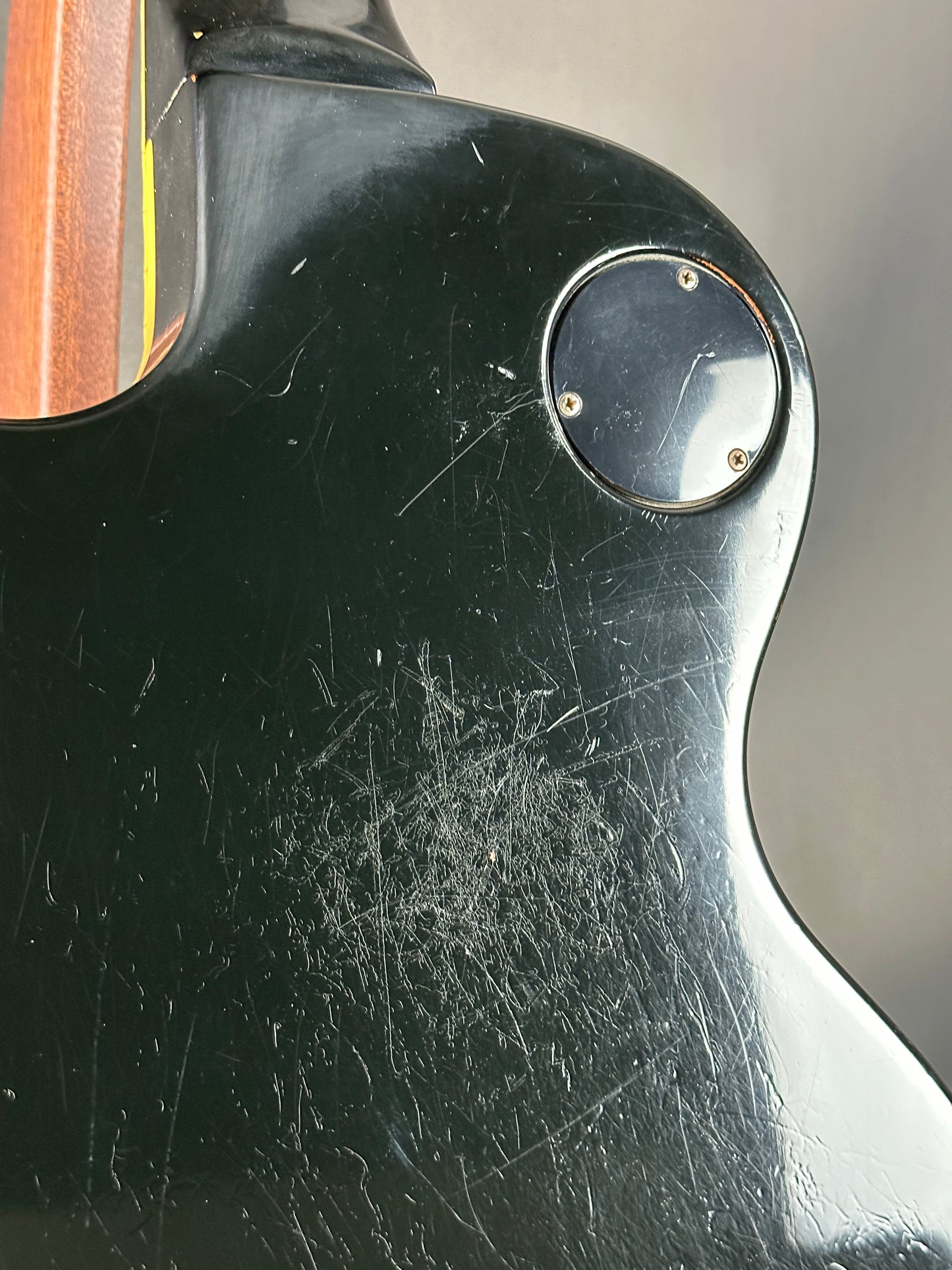 Close-up of a guitar with visible wear and tear on the body