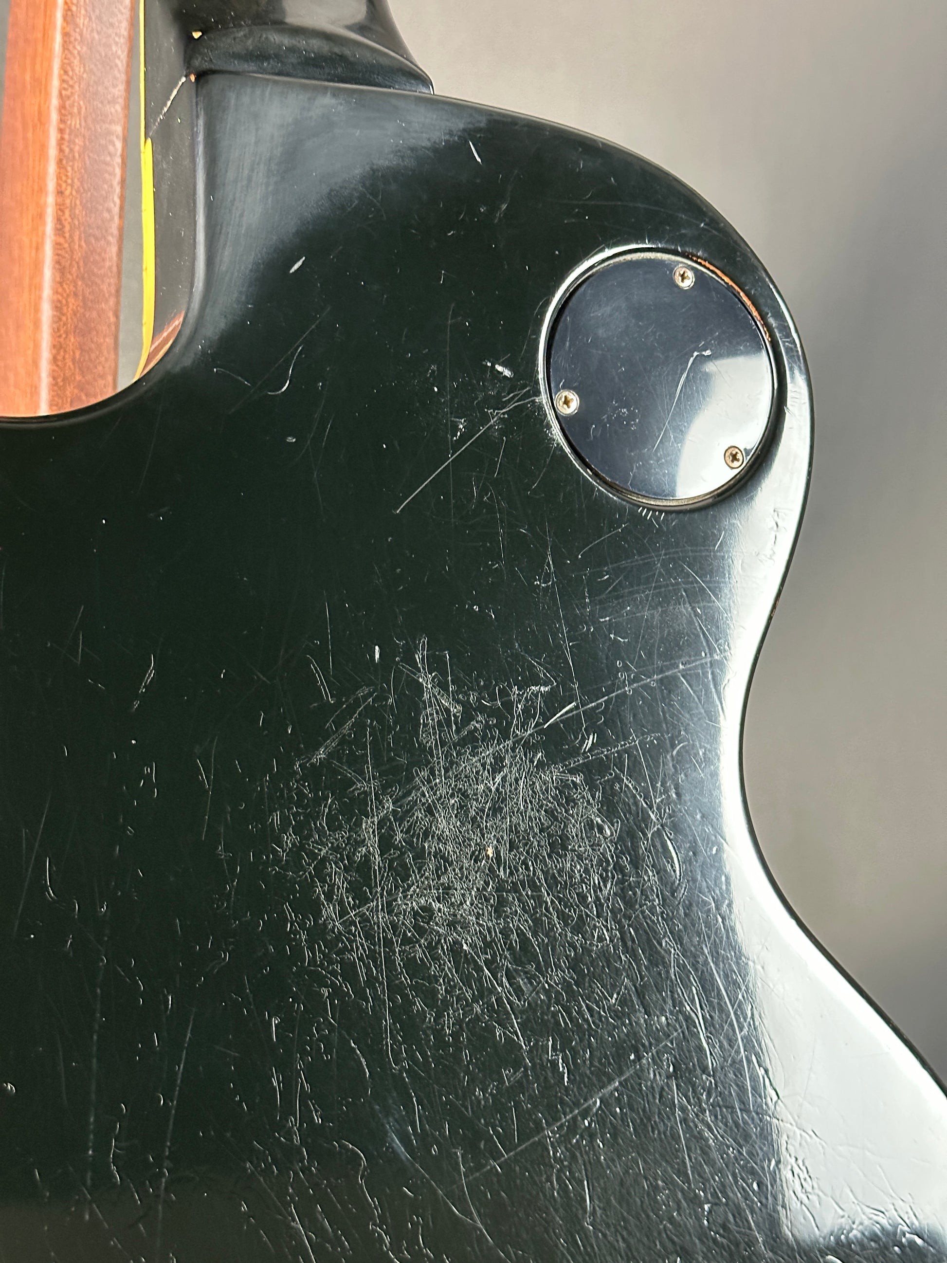 Close-up of a guitar with visible wear and tear on the body
