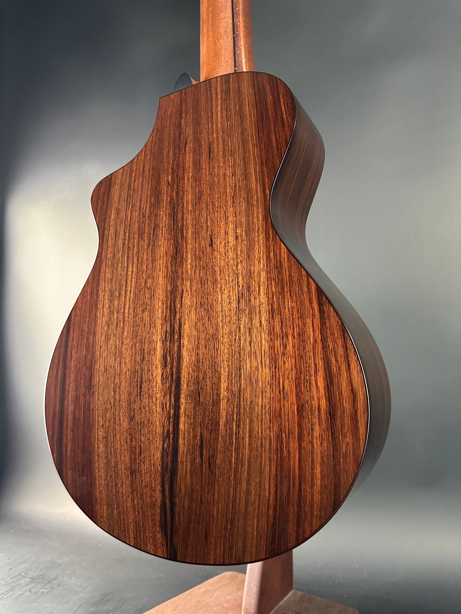 Close-up of a wooden guitar body on a gray background