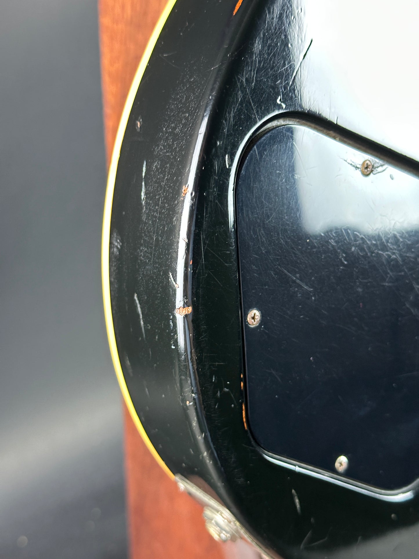 Close-up of a guitar's soundhole with a black pickguard.